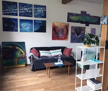 ein Zimmer mit Couch und Kunst an der Wand
